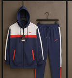 Navy tracksuit with red and white accents on a hanger against a brown background