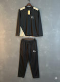 Black Nike tracksuit with white accents on a gray background