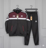 Black and maroon tracksuit with Adidas logo on a gray background